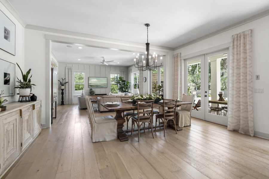 Welcoming open-concept dining and living area with large windows, natural light, and stylish decor in a modern home.