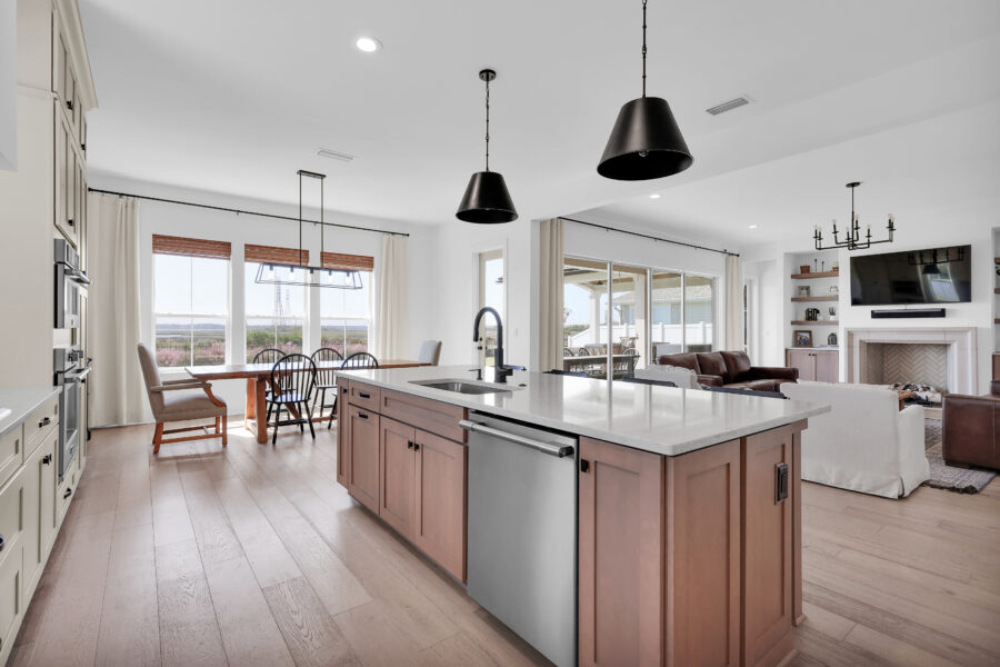 Bright and spacious open-concept kitchen and living area featuring natural light, modern fixtures, and a cozy fireplace, perfect for family gatherings and everyday living.