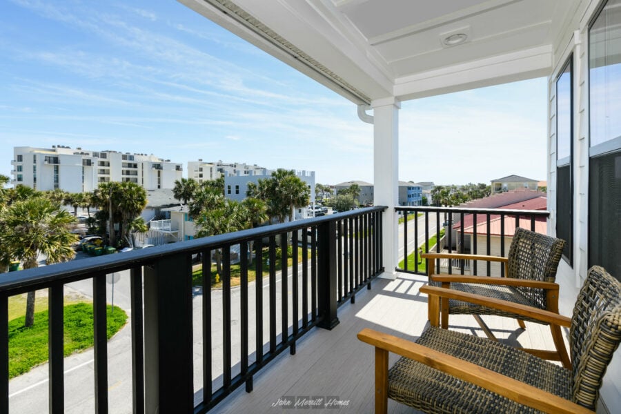 Breathtaking view from a balcony overlooking a tropical neighborhood with palm trees and modern buildings, perfect for relaxing or enjoying outdoor leisure in a coastal community.
