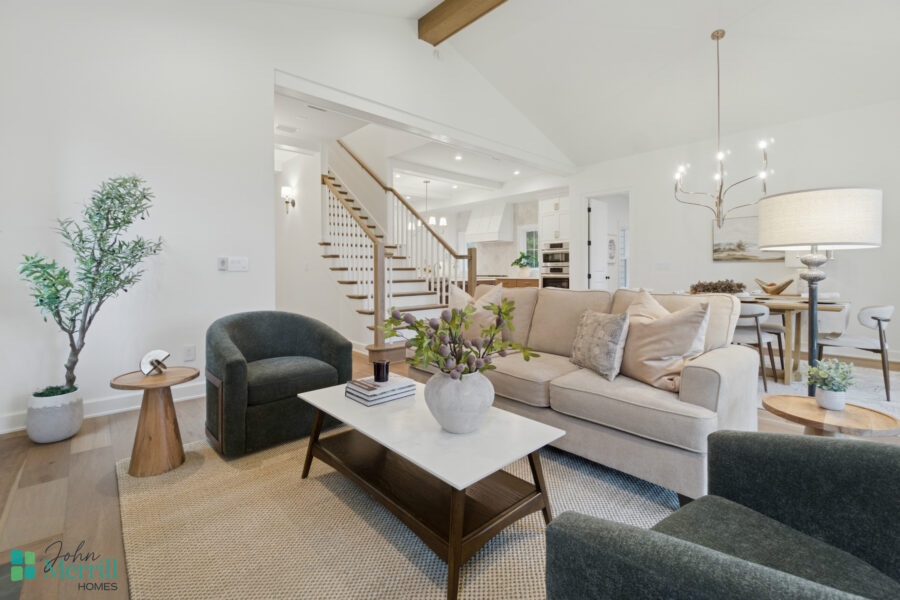 Bright, welcoming living room with neutral-toned furniture, modern decor, and large windows providing natural light in a stylish John Merrill home.