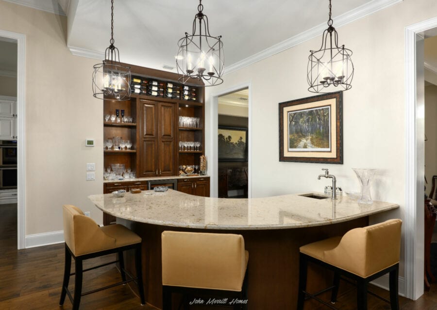 Luxurious kitchen with granite island, wooden cabinetry, and stylish lighting fixtures, ideal for entertaining and family gatherings.