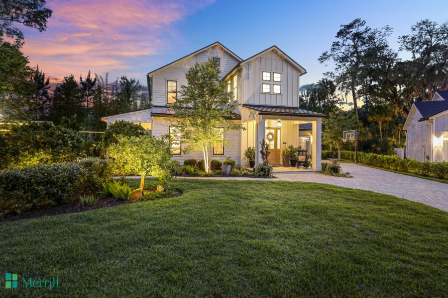 Beautiful two-story house with a well-maintained front yard, lush greenery, and a clear evening sky, showcasing a welcoming residential property.