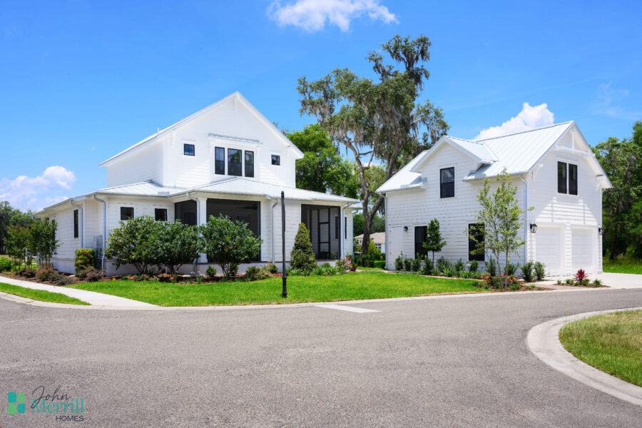 Beautiful white two-story houses with well-maintained lawns, surrounded by greenery and trees, showcasing contemporary residential architecture.