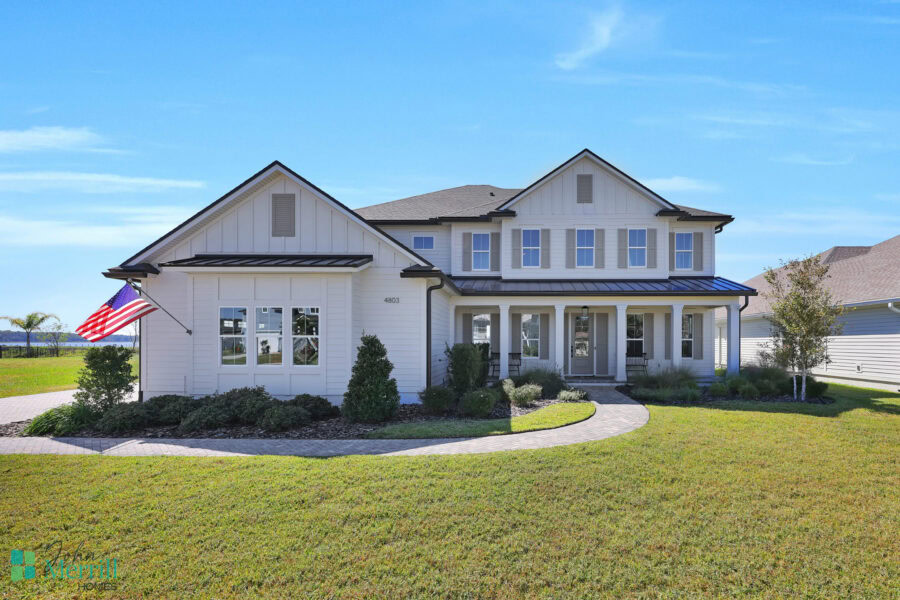 Bright, spacious modern farmhouse with white siding, black roof, and large windows.