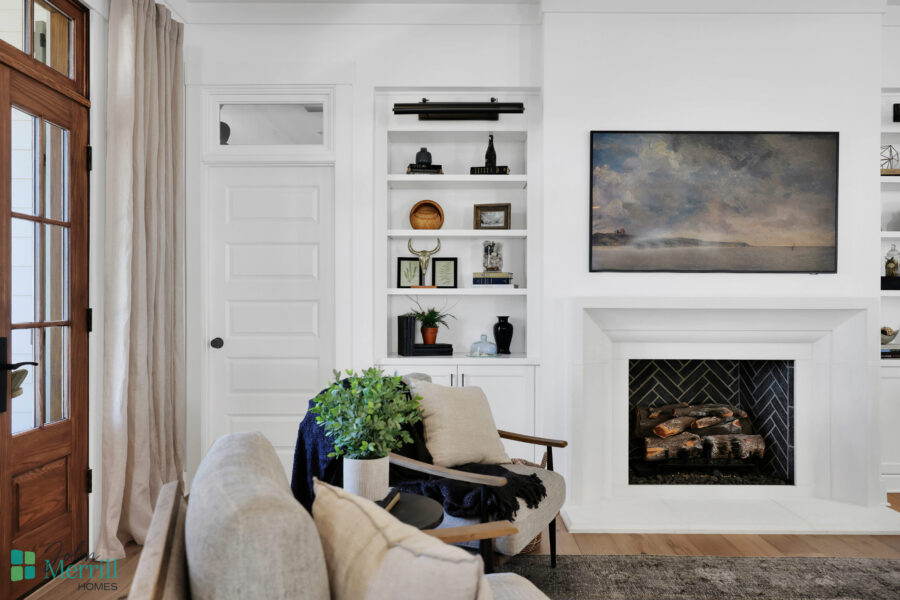 Bright and inviting living room featuring a cozy fireplace, built-in shelves with decorative items, and comfortable seating arrangements. Perfect for relaxing and entertaining guests.