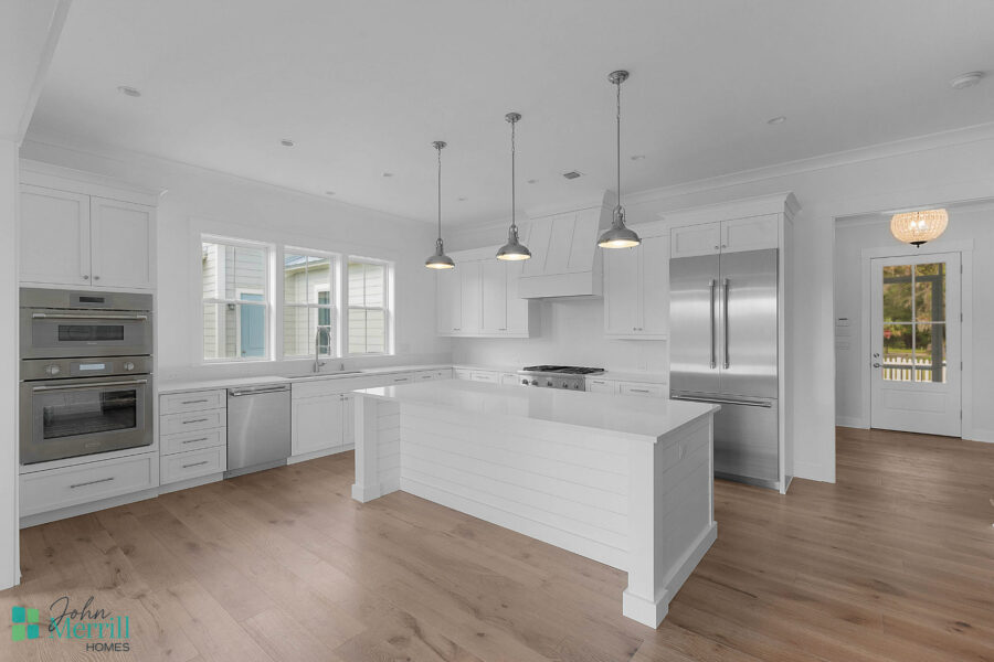 Bright and spacious kitchen featuring white cabinetry, a large island, and stainless steel appliances, perfect for family cooking and entertaining.