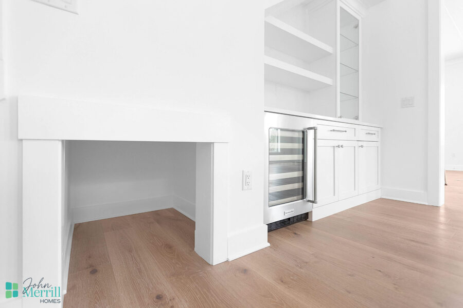 Bright, modern kitchen featuring white cabinetry, a built-in wine cooler, and open shelving, perfect for contemporary living and entertaining.