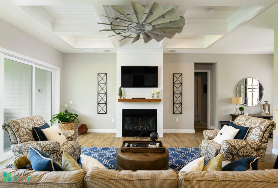 Spacious living room featuring a fireplace, wall-mounted TV, and elegant furniture with decorative pillows, plants, and artwork, creating a welcoming and contemporary atmosphere.