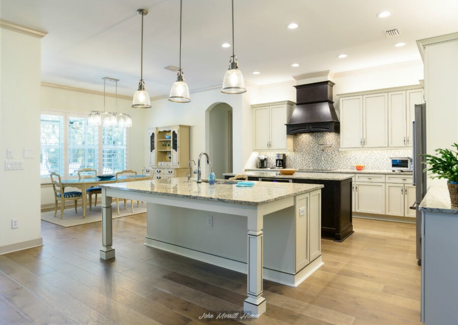 Spacious modern kitchen featuring an island with granite countertop, elegant cabinetry, stainless steel appliances, and a stylish range hood, perfect for family cooking and entertaining guests.