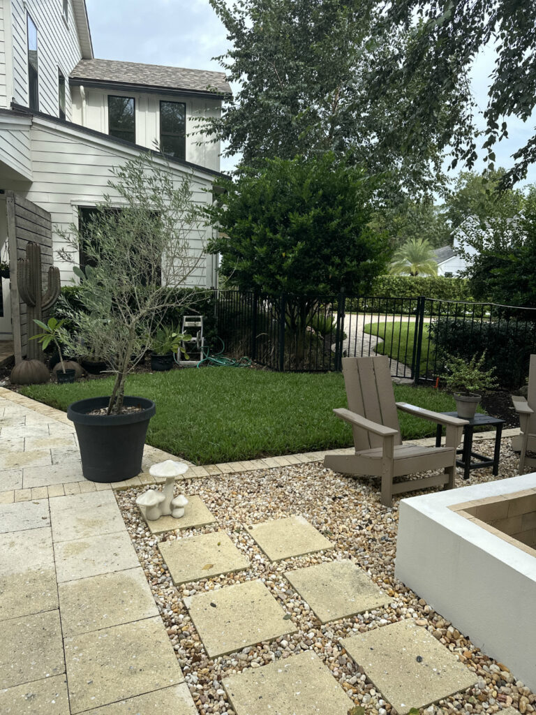 1. Beautiful backyard with potted plants, a lawn, stone pathway, and outdoor seating area, perfect for relaxing and entertaining.