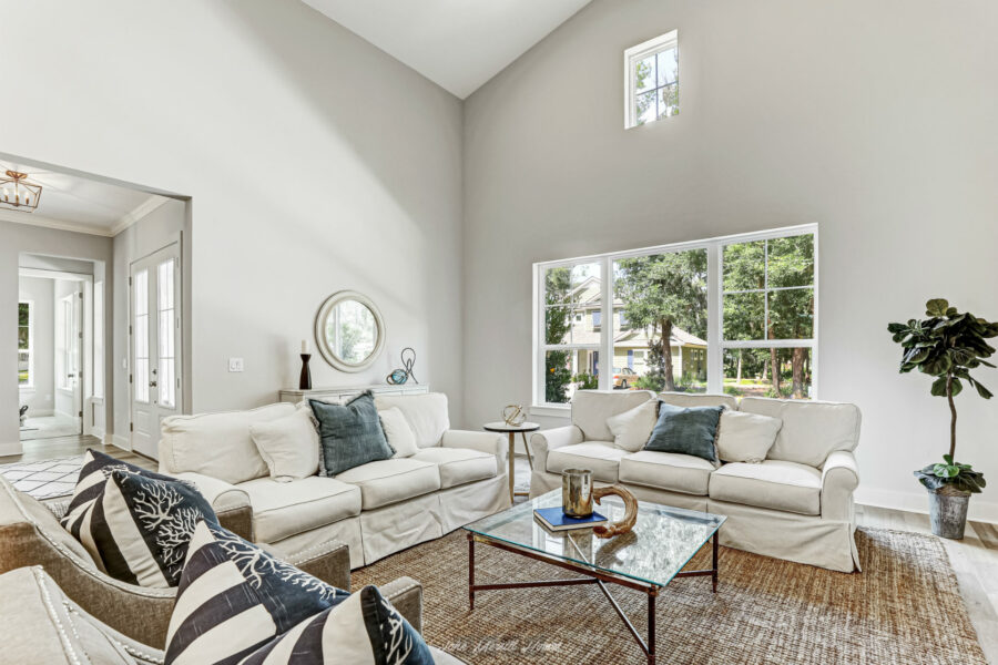 Modern living room with large windows, white sofas, and neutral decor creating a bright, airy, and welcoming space.