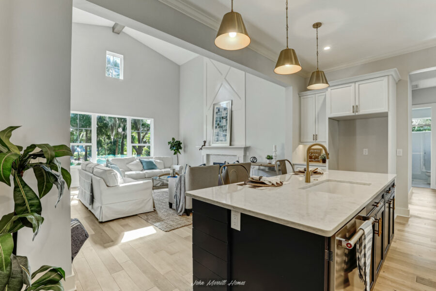 Bright open-concept living room and kitchen with large windows, white walls, modern decor, and natural light. Perfect for family gatherings and entertaining friends in a stylish, airy space.