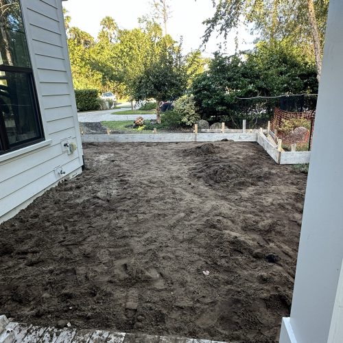 Newly prepared backyard space for landscaping or outdoor living improvement at a John Merrill Homes construction site.