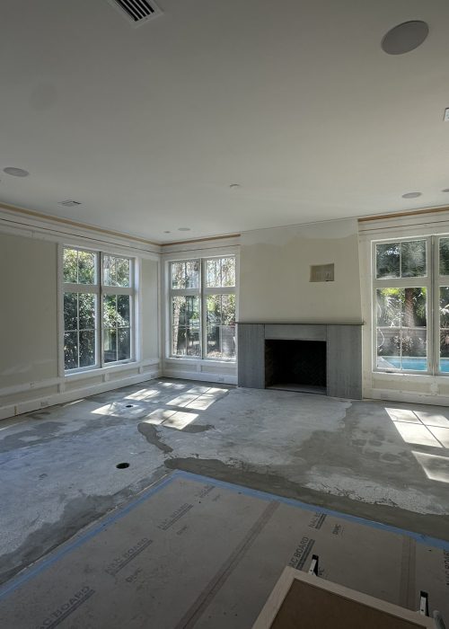 Spacious living room featuring large windows, a central fireplace, and abundant natural light, perfect for family gatherings and relaxation.